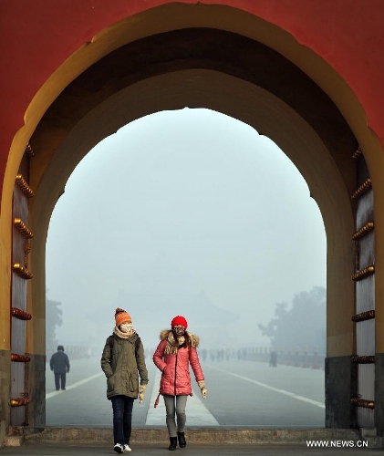   Two visitors wearing masks are seen at the fog-enveloped Temple of Heaven in Beijing, capital of China, Jan. 12, 2013. Heavy fog hit Beijing on Saturday. (Xinhua/Li Wen) 