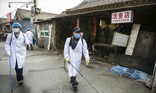 Staff members from the Naidong village committee, in Beijing’s Chaoyang district, disinfect areas of the village on Monday. The municipal health authorities announced on Monday a four-year-old boy surnamed Zhu from the village was an H7N9 flu virus carrier. Photo: Li Hao/GT