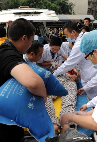 Medical staff carry a quake victim outside the Huaxi Hospital of Sichuan University in Chengdu, capital of southwest China's Sichuan Province, April 22, 2013. The hospital opened a green channel for victims after a 7.0-magnitude earthquake jolted Lushan County of Ya'an City in Sichuan on April 20 morning. As of 12 a.m. on April 22, the hospital has received 229 injured people. (Xinhua/Li Ziheng)