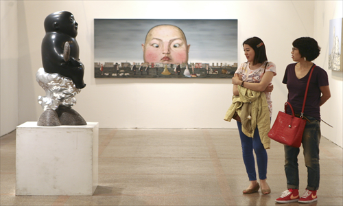 Visitors take in an exhibition of art from China, Japan and South Korea at the Shanghai Exhibition Center in May 2012 that aimed to promote cooperation in art market between the three countries. Photo: CFP