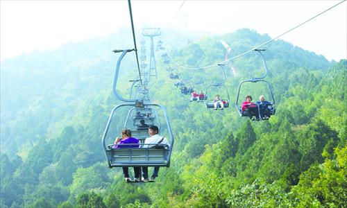 Visitors to Fragrant Hills Park take a ride in cable cars. Photo: Tom Fearon/GT 