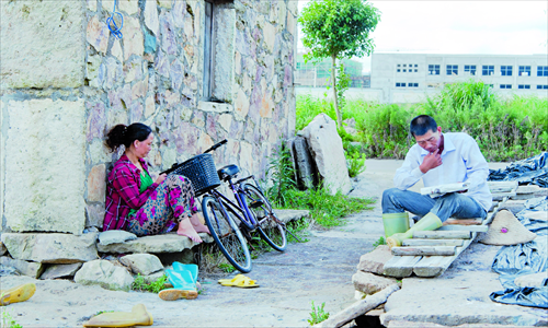 Two salt workers rest beside the salt field. Photo: CFP