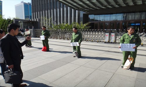 Four men, who claim to be former employees of Sinopec and veterans of the border conflict between China and Vietnam in 1979, protest outside the State-owned enterprise's headquarter in Beijing on Thursday. They say the oil giant is withholding their severance pay after ending their employment. Protests by retired servicemen have emerged across the country in recent years, and the military and civil authorities have been promoting in-service training to prepare them for future employment. Photo: Yin Yeping/GT