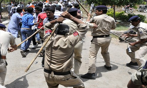 Policemen cane-charge Congress party activists during a strike called by Congress party workers to protest against a Maoist attack, in Bhopal, India on May 27. Maoists opened fire on the Congress party Parivartan Yatra in Chhattigarh state on May 25. Photo: CFP