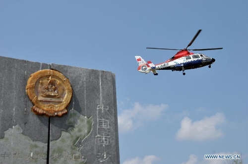 A marine surveillance helicopter flies over the Ganquan Island, an uninhabited island of the Xisha Islands in the South China Sea, March 11, 2013. Crew members aboard the Chinese marine surveillance ship Haijian 262 patrolled the Ganquan Island on Monday. (Xinhua/Wei Hua) 