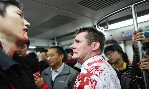 A pair of bloody actors spook subway passengers on Sunday. The two students from Beijing Film Academy had just finished shooting a short film about Halloween. Photo: CFP