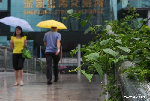 Pedestrians walk amid rain in Shenzhen, south China's Guangdong Province, May 26, 2013. Torrential rain hit most parts of Guangdong Province from Saturday to Sunday. (Xinhua/Mao Siqian)&nbsp; 