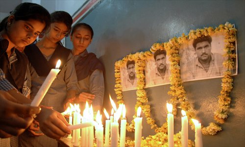 Indian students pose with lighted candles as they pay tribute to the late Sarabjit Singh at a school in Amritsar on Thursday.  Singh, who was sentenced 16 years ago over deadly bombings, died in the early hours as a result of the savage assault in Lahore's Kot Lakhpat jail, a senior doctor at Jinnah hospital in the eastern city told AFP.  Photo: AFP