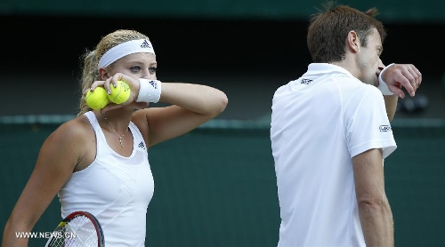 Daniel Nestor of Canada and Kristina Mladenovic (L) of France compete during the final of mixed doubles against Bruno Soares of Brazil and Lisa Raymond of the United States on day 13 of the Wimbledon Lawn Tennis Championships at the All England Lawn Tennis and Croquet Club in London, Britain, on July 7, 2013. Daniel Nestor and Kristina Mladenovic claimed the title with 2-1. (Xinhua/Wang Lili) 