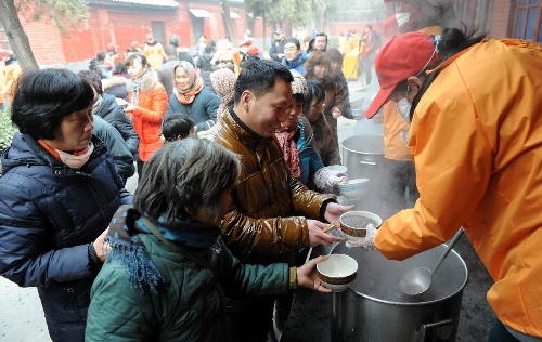  Citizens queue to get free porridge at White Horse Monastery in Luoyang, central China's Henan Province, Jan. 19, 2013. The White Horse Monastery distributed Laba porridge for free on Jan. 19, the eighth day of the 12th lunar month or the day of Laba Festival. The Laba Festival is regarded as a prelude to the Spring Festival, or Chinese Lunar New Year, the most important occasion of family reunion, which falls on Feb. 10 of this year. Drinking Laba porridge on the day of Laba is a traditional custom in China. (Xinhua/Li Bo) 