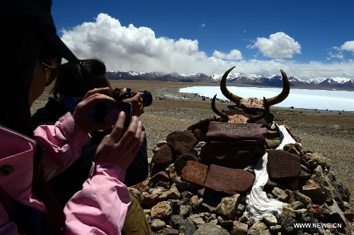 Tourists take photos of the scenery around the icy lake Nam Co located at the boundary of Damxung and Baingoin counties, southwest China's Tibet Autonomous Region, on May 12, 2013. Lake Nam Co, the highest saltwater lake of the world at 4,718 meters above the sea level, is regarded as a sacred lake in Tibetan Buddhism. (Xinhua/Chen Tianhu)
