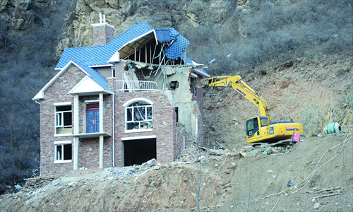 A bulldozer dismantles hillside villas with limited rights in a scenic spot in Changping, Beijing, on November 25. Photo: CFP