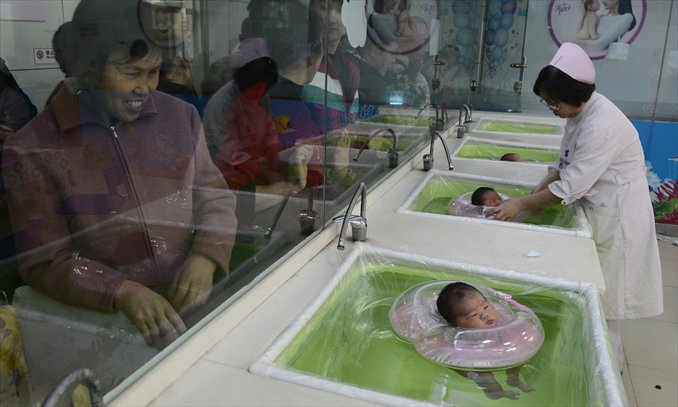 A nurse tends to babies swimming at a hospital in Taiyuan, Shanxi Province on December 3, 2012. Photo: CFP