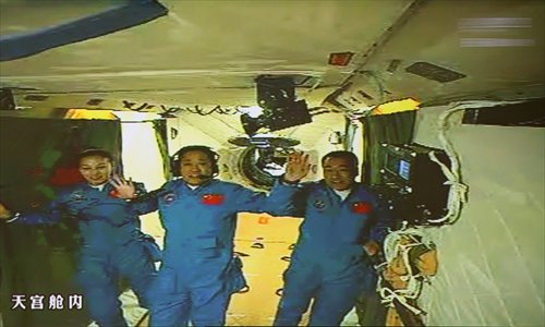 This image cropped from a video clip shows three Chinese astronauts, Wang Yaping (left), Nie Haisheng (center) and Zhang Xiaoguang, float from the Shenzhou-10 spaceship into the module Tiangong-1 Thursday afternoon after the successful docking. Photo: CFP