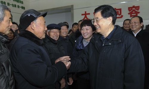 Photo released on December 29, 2012 shows Chinese President Hu Jintao (R, front) talks with villagers of Hengbei Village in Dazhong Town, Yancheng City, east China's Jiangsu Province.