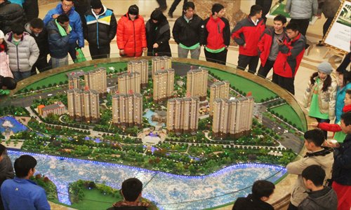 Residents in Xuchang, Henan Province, look at models of a residential complex at a real estate company on December 23, 2012. Photo: CFP