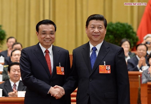 Xi Jinping (R) shakes hands with Li Keqiang at the fifth plenary meeting of the first session of the 12th National People's Congress (NPC) at the Great Hall of the People in Beijing, capital of China, March 15, 2013. Li Keqiang was endorsed as the premier of China's State Council at the meeting here on Friday. (Xinhua/Ma Zhancheng)