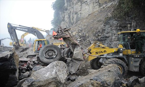 Rubble is seen scattered along the road connecting Baoxing county and Lingguan township in the quake-hit city of Ya'an in Sichuan Province Monday morning. The artery, which was blocked following the quake, reopened Monday. Photo: Li Hao/GT