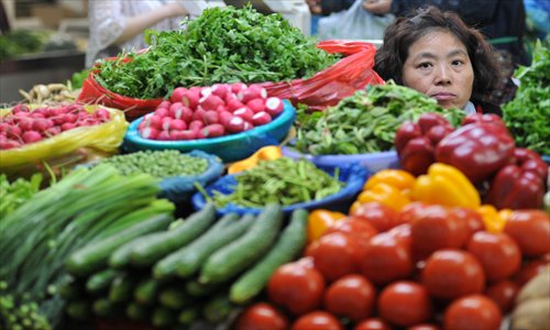 A vegetable vendor awaits customers at a farmers’ market in Nanjing, East China’s Jiangsu Province Saturday. Photo: CFP