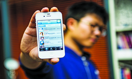 A consumer holds an iPhone 4S, which shows a few books with seductive names. Photo: Li Hao/GT