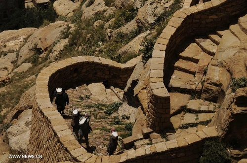 &nbsp;Yemeni workers carry substances used in renovating a path that leads to the Thula Fort at the historical city of Thula, 45 km north of Sanaa, Yemen, on May 12, 2013. Thula Fort is one of 20 nominees for the 2013 Aga Khan Award for Architecture which is given every three years to projects that set new standards of excellence in architecture, planning practices, historic preservation and landscape architecture, in which Muslims have a significant presence. Thula boasts an impressive collection of stone buildings that date back to the 1st millennium BCE. The Thula fort was threatened by the disruption that might ensue from the construction of a road. However, the Yemeni government has undertaken a series of historic preservation projects to protect cultural assets, including rebuilding the walls of burial grounds, watch towers, paths and waterways, and repairing the cistern that remains in use to this day.(Xinhua/Mohammed Mohammed) 
