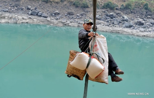 A man from Shuangmidi Village crosses the Nujiang River via a zip-line in Lushui County of Nujiang Lisu Autonomous Prefecture, southwest China's Yunnan Province, Feb. 2, 2013. More than 98 percent of Nujiang Lisu Autonomous Prefecture is occupied by mountains and valleys. The zip-lines have been quite popular transportation method along the Nujiang River since the ancient time. However, as transport conditions improve in recent years, a growing number of traditional zip-lines along the Nujiang River Valley have been dismantled or replaced by bridges. (Xinhua/Lin Yiguang)  