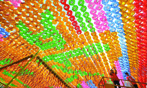 A South Korean worker attaches name cards with wishes of Buddhist followers to lotus lanterns during a ceremony to celebrate the birthday of Buddha at Jogye Temple in Seoul on Friday. Buddhism is one of South Korea's largest and most active religions. It has millions of followers in the country. Although the exact date is unknown, Buddha's official birthday is celebrated on April 8 of the lunar calendar, which is Friday this year, in China, South Korea, Japan and Mongolia. Photo: AFP
