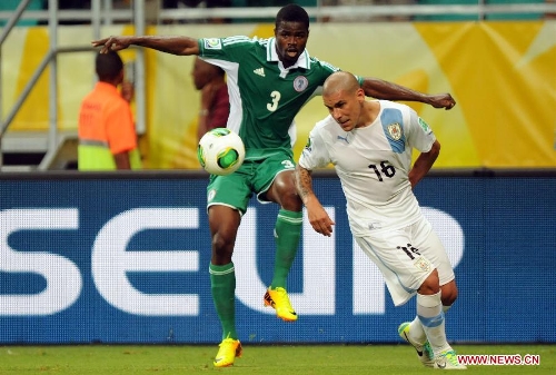 Nigeria's Uwa Echiejile (L) vies for the ball with Maximiliano Pereira of Uruguay during the FIFA's Confederations Cup Brazil 2013 match in Salvador, Brazil, on June 20, 2013. Uruguay won 2-1. (Xinhua/Nicolas Celaya)  