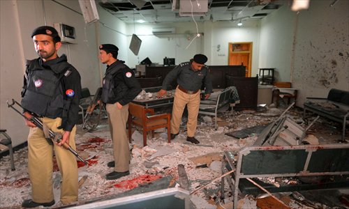 Pakistani policemen examine a damaged office following a suicide attack on a court complex in Peshawar on Monday. Four people were killed when a suicide bomber posing as a legal clerk blew himself up and his companion opened fire at a courthouse, officials said. Photo: AFP