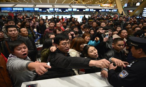 Stranded passengers vent their anger at a check-in counter of China Eastern Airlines at the Changshui International Airport in Kunming, Yunnan Province Friday, after a dense fog grounded 440 flights on Thursday. Photo: CFP