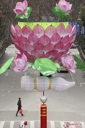 A man walks under a giant lotus lantern in Nanjing, capital of east China's Jiangsu Province, Feb. 8, 2013. The Spring Festival, the most important occasion for the family reunion for the Chinese people, falls on the first day of the first month of the traditional Chinese lunar calendar, or Feb. 10 this year. Photo: Xinhua