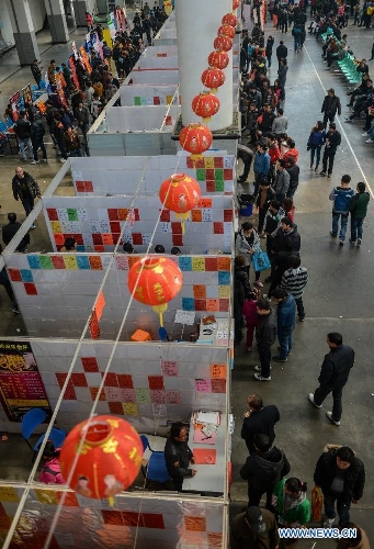 People look for career opportunities at a job fair in Yiwu, east China's Zhejiang Province, Feb. 16, 2013. China has begun to see a resurgence in the number of both employers and job seekers after the week-long Spring Festival holiday. (Xinhua/Han Chuanhao)
