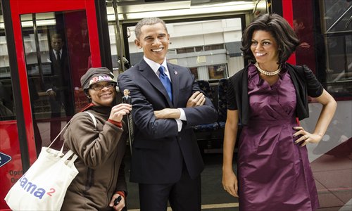 Teri McClain of Seattle poses with wax figures of President Barack Obama and First Lady Michelle Obama during the Madame Tussauds DC Presidential Wax Figures Bus Tour on Thursday in Washington, DC. Photo: AFP