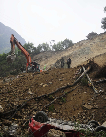 An excavator works to clear debris after a landslide on April 23 near Baoxing county, Ya’an, Sichuan Province. Road-clearing teams are on duty 24 hours a day, but landslides and falling stones mean that rescuers are risking their lives to get through. Photo: Li Hao/GT