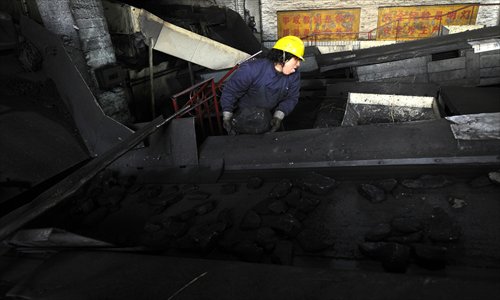 A female worker sorts through chunks of coal in Jiexiu, North China's Shanxi Province. Photo: CFP