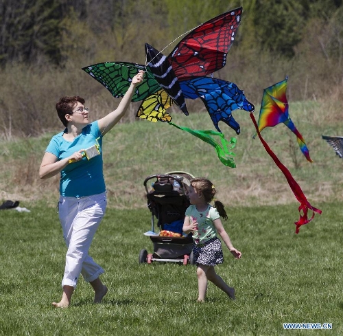 People fly kites during the 24th Annual Four Winds Kite Festival at the Kortright Centre for Conservation in Toronto, Canada, May 4, 2013. (Xinhua/Zou Zheng)