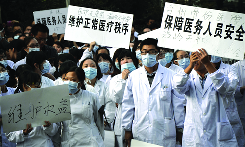 Medical workers holding up placards gather to protest violence against hospital staff at the No.1 People's Hospital in Wenling, Zhejiang Province, Monday. Photo: IC