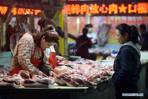 A consumer selects pork at a food market in Dehui City, northeast China's Jilin Province, May 9, 2013. China's consumer price index (CPI), a main gauge of inflation, grew 2.4 percent year on year in April, up from 2.1 percent in March, the National Bureau of Statistics (NBS) said Thursday. The NBS attributed the gain mainly to an unusual increase in vegetable prices during that month as low temperatures and scarce rainfalls disrupted supplies. (Xinhua/Lin Hong)