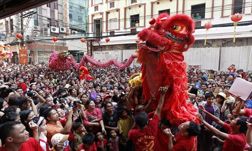 Filipinos perform a dragon dance outside a grocery store as they mark Chinese New Year in the Chinatown district of Manila in January. Photo: CFP