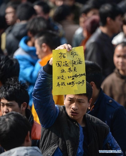 A logistics company staff member looks for prospective applicants at a job fair in Yiwu, east China's Zhejiang Province, Feb. 16, 2013. China has begun to see a resurgence in the number of both employers and job seekers after the week-long Spring Festival holiday. (Xinhua/Han Chuanhao)