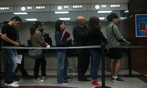 Foreigners queue at the exit-entry section of the Municipal Public Security Bureau in Beijing. Some agencies renew expired visas to help expats avoid serving jail time or being deported from China. Photo: CFP