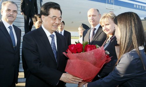 Chinese President Hu Jintao (L front) receives flowers as he arrives in Russia's Far Eastern city of Vladivostok, Sept. 6, 2012, for the annual economic leaders' meeting of the 21-member Asia-Pacific Economic Cooperation (APEC) forum slated for Saturday and Sunday. Photo: Xinhua