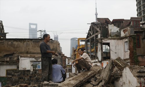 Workers take a break among the debris of a demolition site in Hongkou district. Photo: Cai Xianmin/GT 