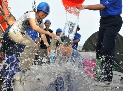 Staff members welcome Qiu Jianwen, a professor from Hong Kong Baptist University, to celebrate his return with China's manned deep-sea submersible Jiaolong after a sample-capture mission in the cold vents of south China sea, south China, June 19, 2013. Qiu obtained deep-sea samples in the cold vents of the South China Sea during a dive conducted on Wednesday. (Xinhua/Zhang Xudong)