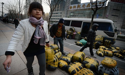 Chinese traders deliver packages to a clothing market in Beijing on Monday.  China's monthly trade surplus fell to $19.6 billion in November, down 38.6 percent from October, the government said Monday, as weak overseas demand weighed on the world's second-largest economy.  Photo: AFP