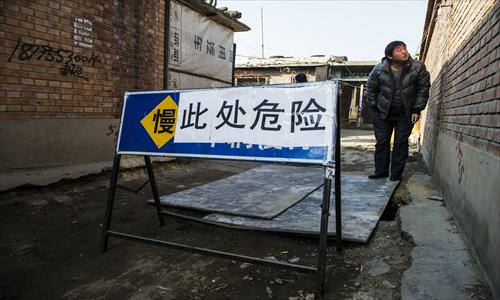 A man stands precariously close to a sinkhole in Jijiamiao village, Fengtai district. The hole sparked panic after it devoured a car on February 18. Photo: Li Hao/GT
