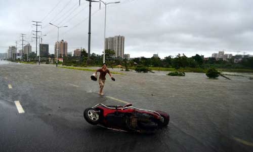 A motorbike is blown down by the wind on a road in Beihai City, south China's Guangxi Zhuang Autonomous Region, Aug. 17, 2012. Typhoon Kai-Tak, the 13th tropical storm of the year, has whirled into Beibu Gulf in Guangxi on Friday afternoon and would probably land on southern Guangxi from Friday evening to Saturday morning, according to the local authority. More than 220,000 residents of Guangxi have been evacuated because of the impact of Typhoon Kai-Tak until 7 p.m. on Friday. Photo: Xinhua
