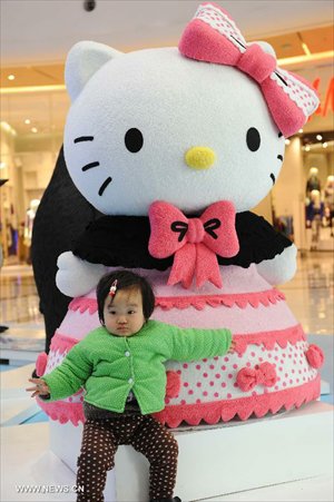 A child poses for pictures in front of a Hello Kitty in the Joy City in east China's Shanghai Municipality, Nov. 26, 2012. A big Hello Kitty exhibition themed on Hello Kitty's exploration in the polar regions would last from Nov. 24, 2012 to Feb. 24, 2013 in Shanghai. Photo: Xinhua