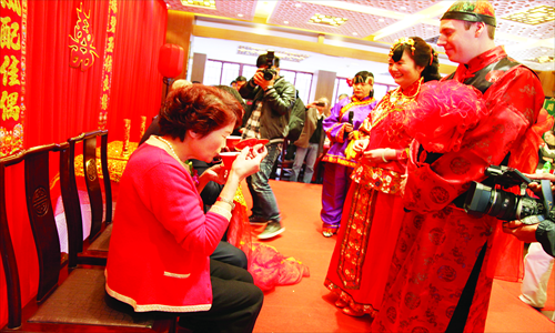 During a traditional Chinese wedding in Shanghai, a foreigner and his wife offer tea to his mother-in-law. Photo: IC