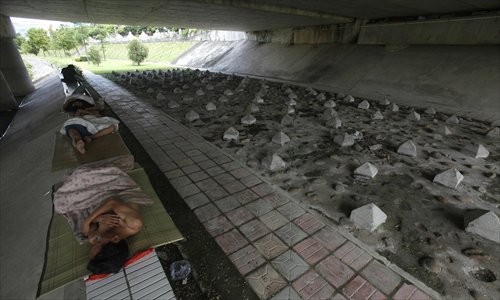 Homeless people sleep on the ledge of an overpass in Shenzhen, Guangdong Province yesterday, after their former 